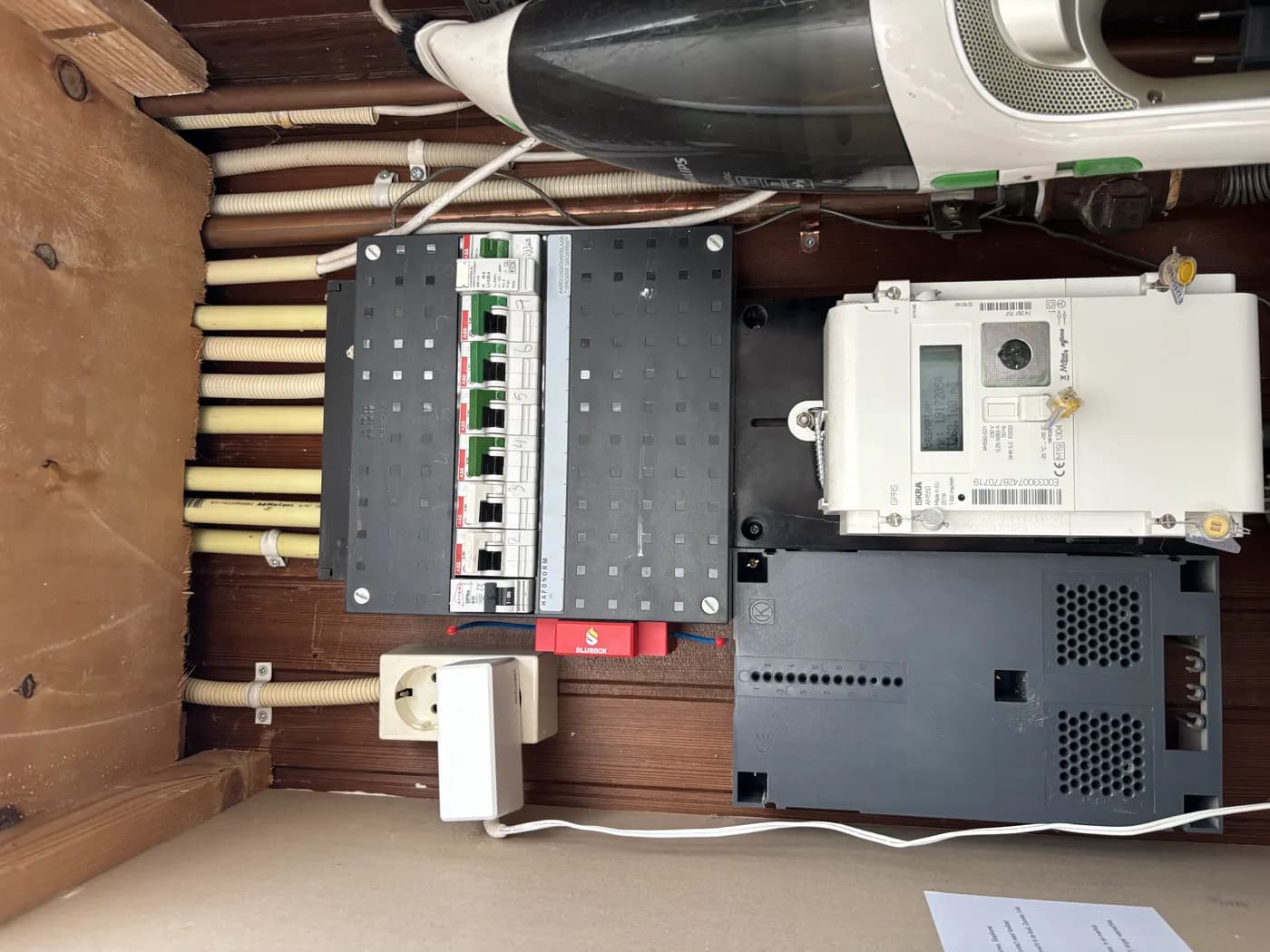 Houten meterkast met slimme meter, met de Blusbox onderaan de groepenkast
